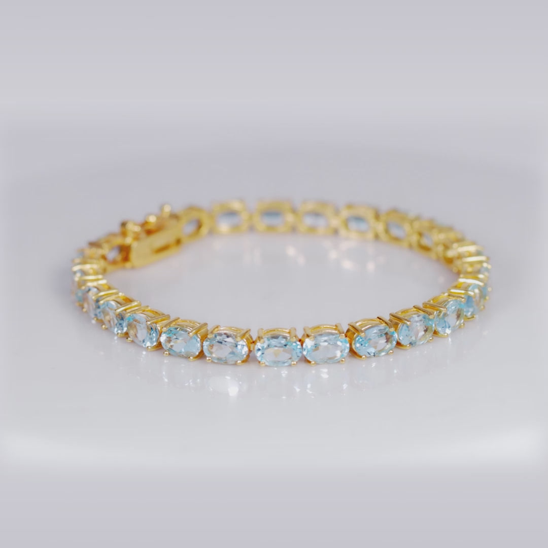 Load video: 925 Sterling Silver 18K Gold Plated Blue Topaz Oval Tennis Bracelet 7.25 Inches